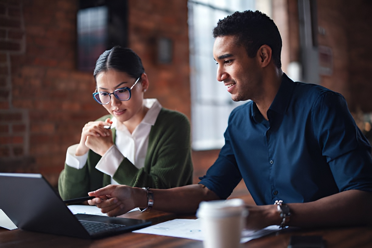 two employees using a laptop while collaborating